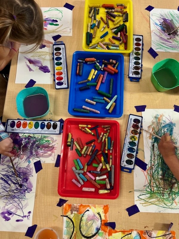 Children drawing and painting with watercolor and crayons.